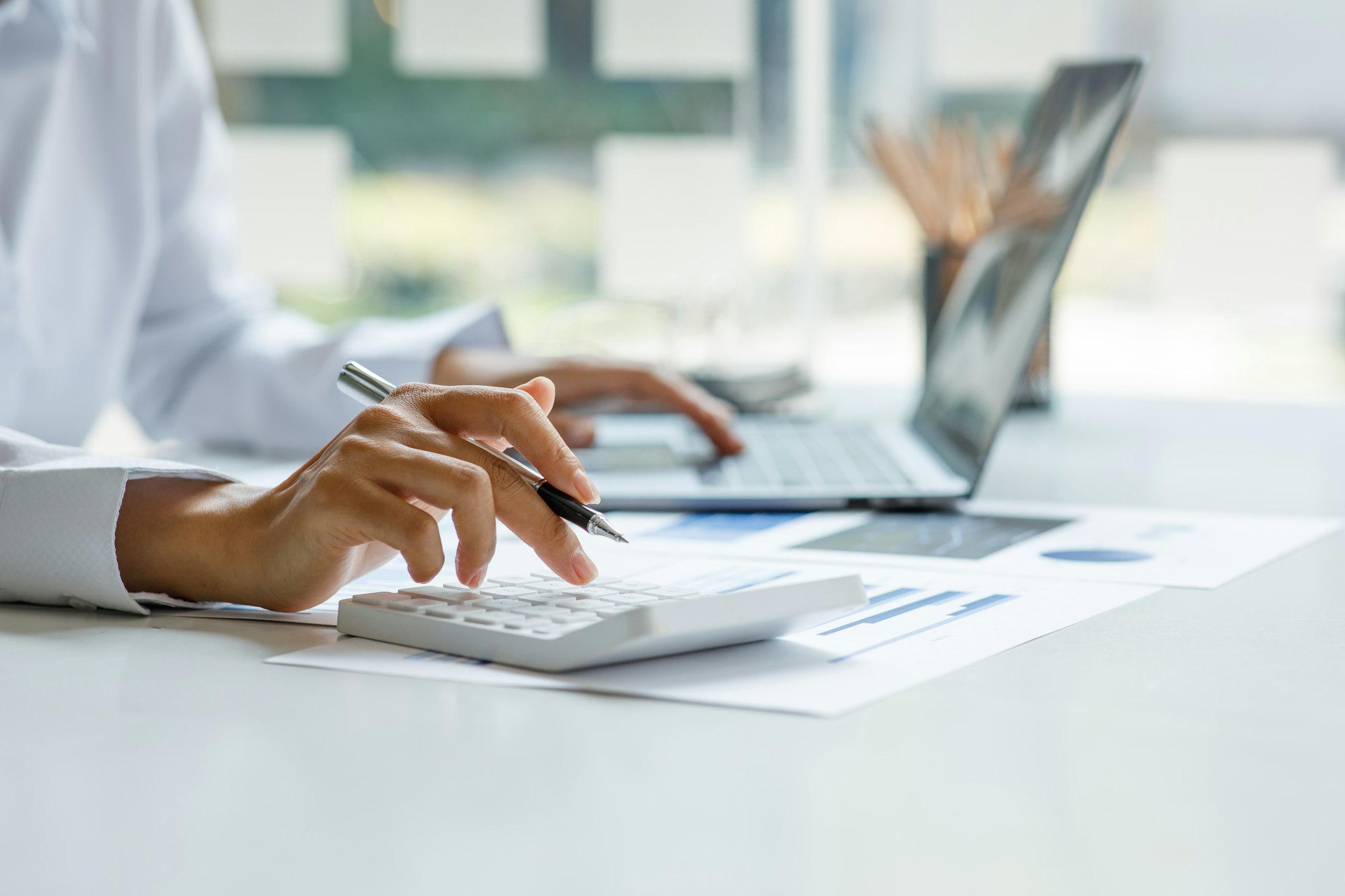 Close up of businesswoman Accounting using calculating income-expenditure and analyzing real estate