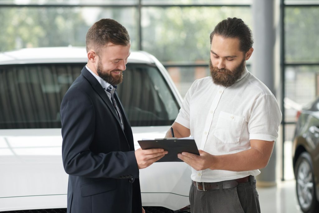 Manager selling car to happy client