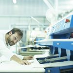 Machine de mise sous pli : optimisez le traitement de votre courrier Man in launderette using laundry folding machine